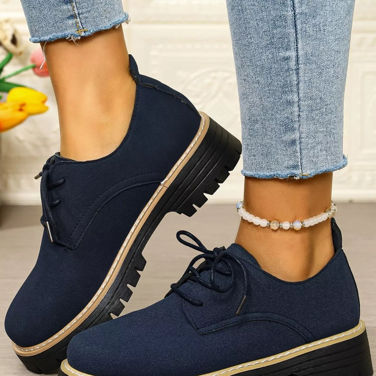 Navy blue shoes with black soles worn with light blue jeans.