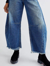 Blue jeans with a frayed hem on a white background