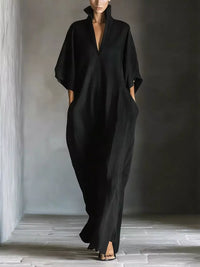 Person wearing a black outfit standing in a minimalistic setting