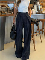 Person wearing a white top and black pinstripe pants in a cafe setting