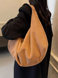 Person wearing a tan shoulder bag indoors