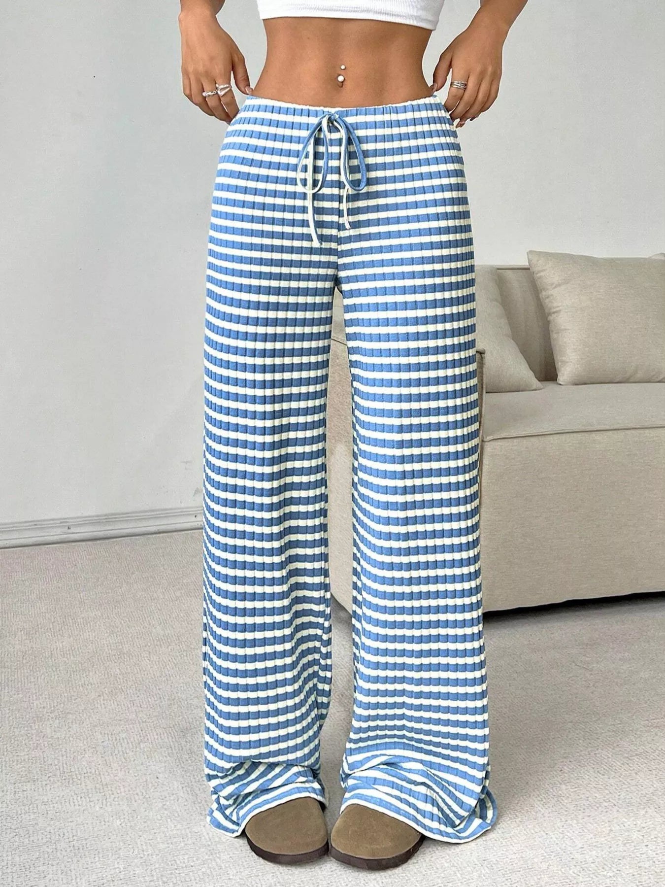 Blue and white striped pants worn by a person in a casual setting.