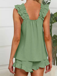 Green ruffled top and shorts set worn by a person, with a blurred indoor background.