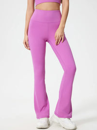 Person wearing pink flared pants on a white background