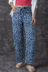 Person wearing blue patterned pants with a plain background