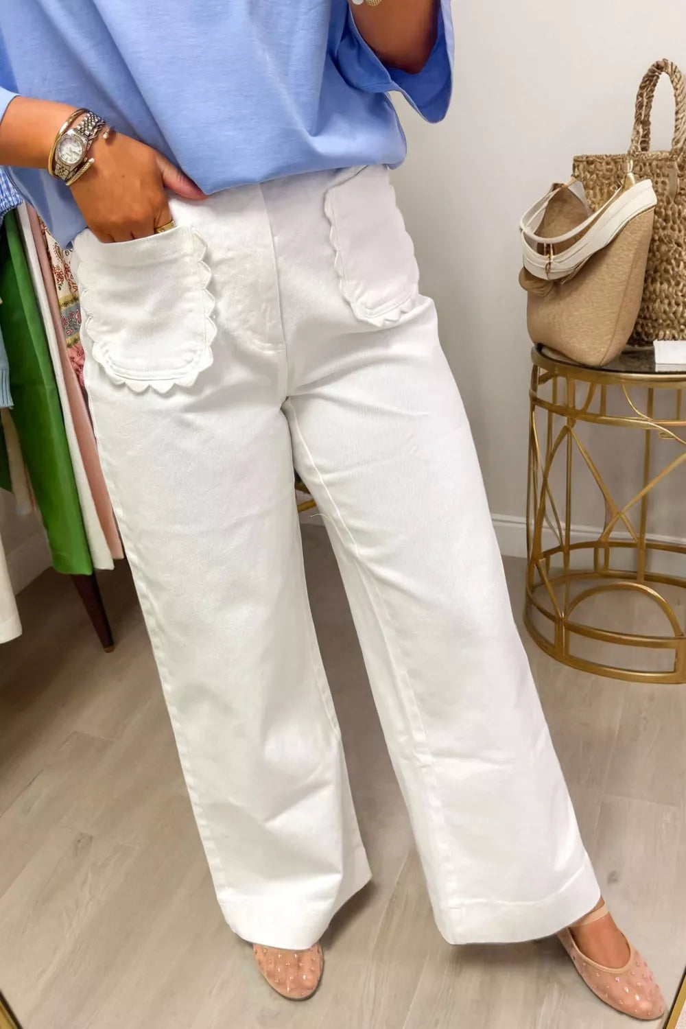 Person wearing white pants with lace details in a casual setting.