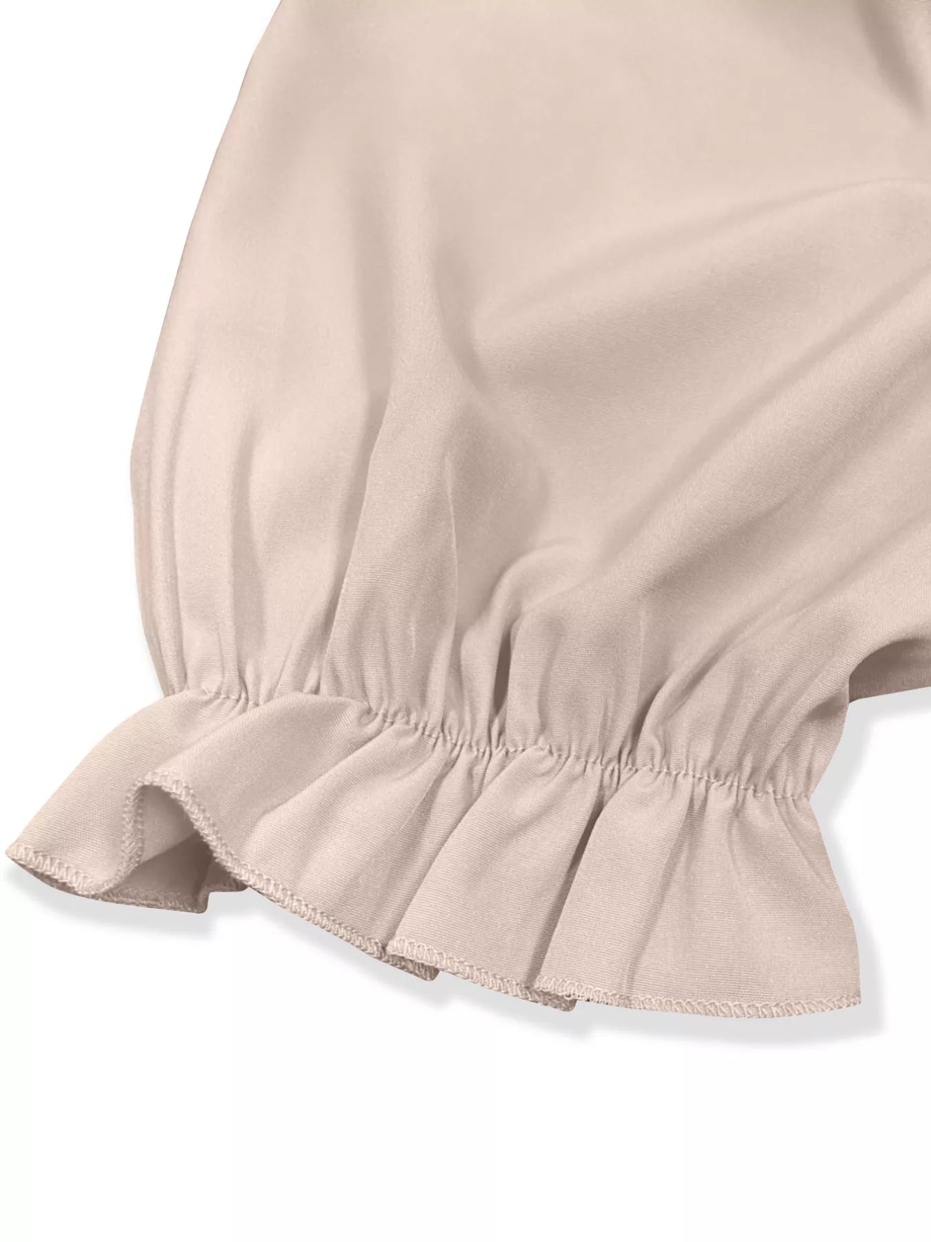 Close-up of a beige skirt with ruffled hem on a white background
