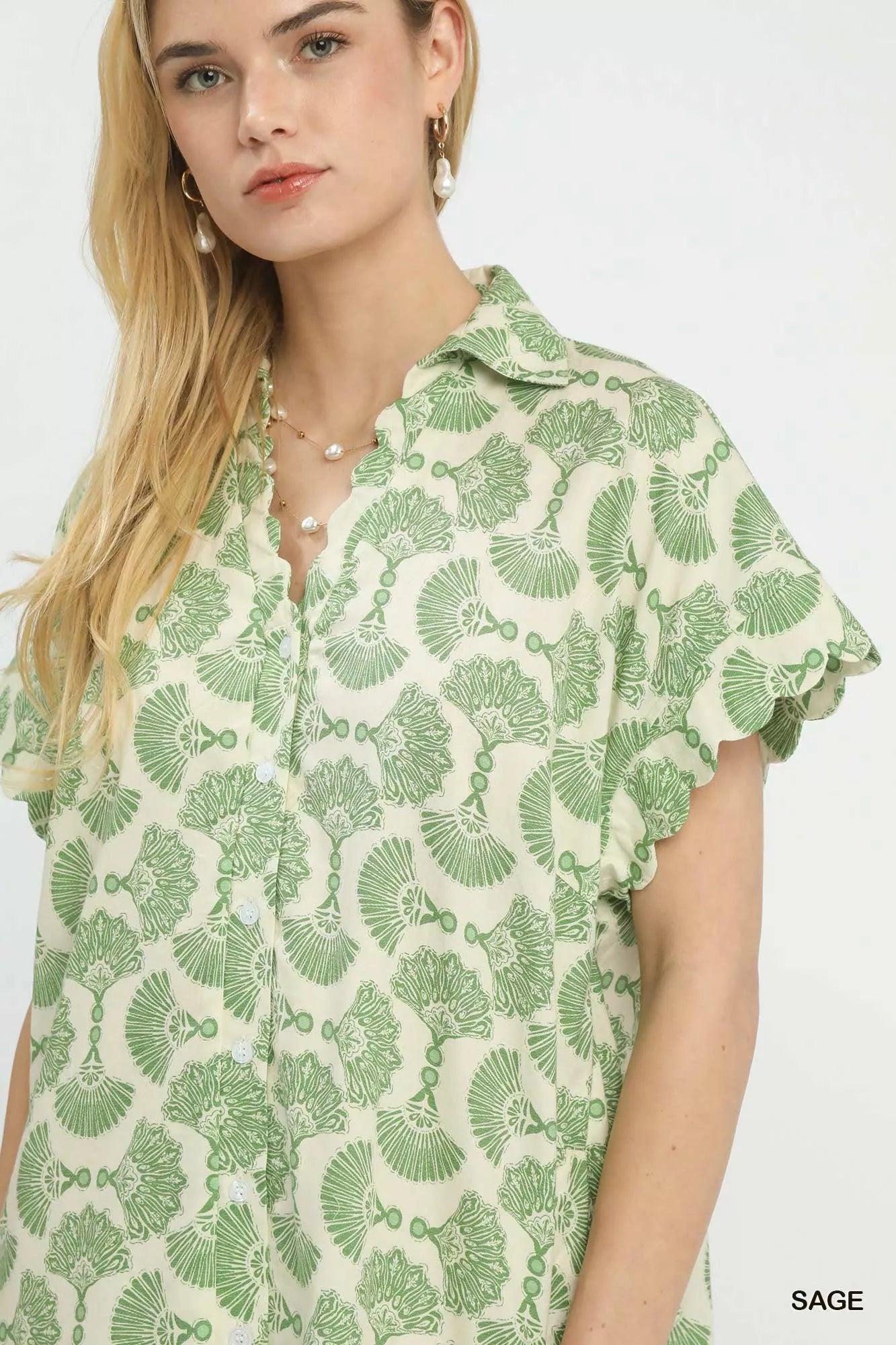 Woman wearing a green and white patterned shirt on a white background