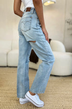 Person wearing light blue jeans and white sneakers in a casual setting