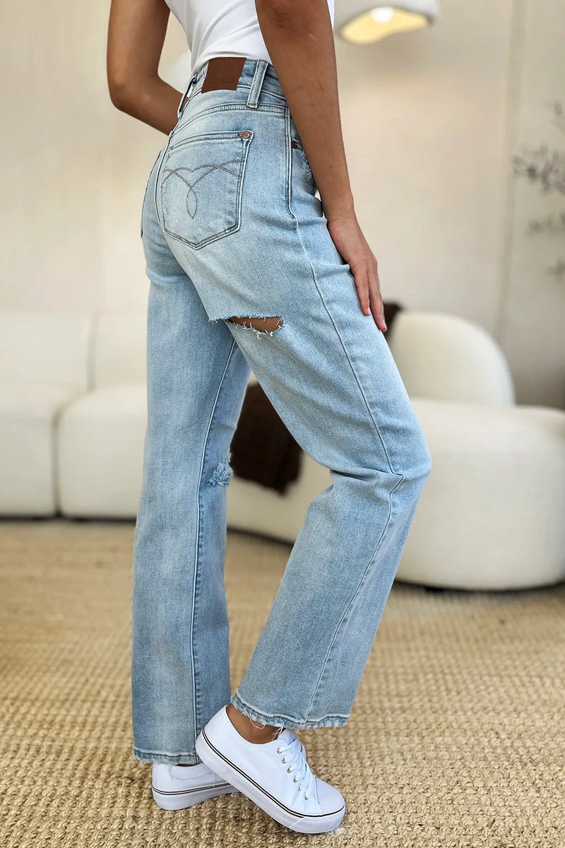Person wearing light blue jeans and white sneakers in a casual setting