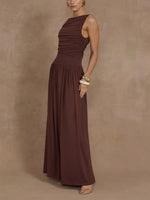 Woman wearing a brown sleeveless dress against a beige background