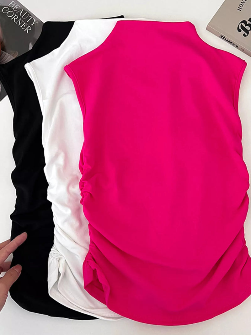 Pink sleeveless top with black and white pants on a white background