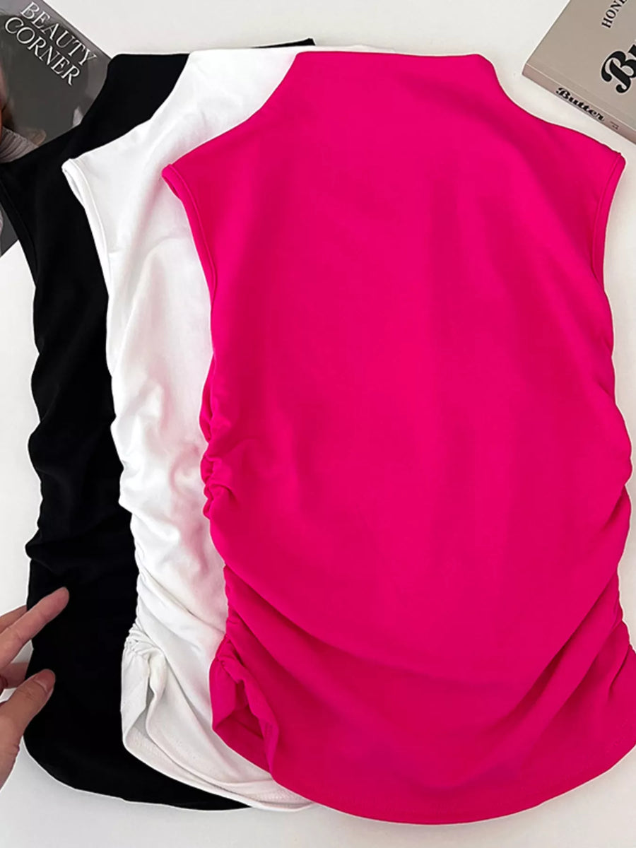 Pink sleeveless top with black and white pants on a white background