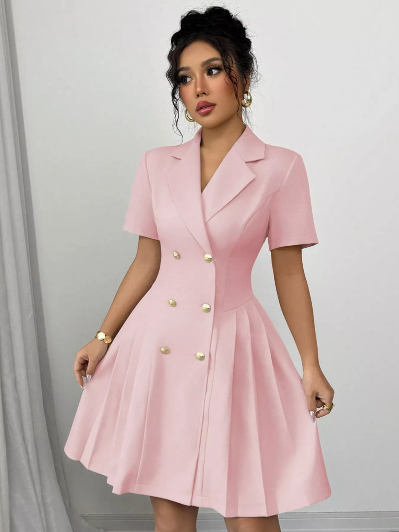 Woman wearing a pink dress with gold buttons against a white background