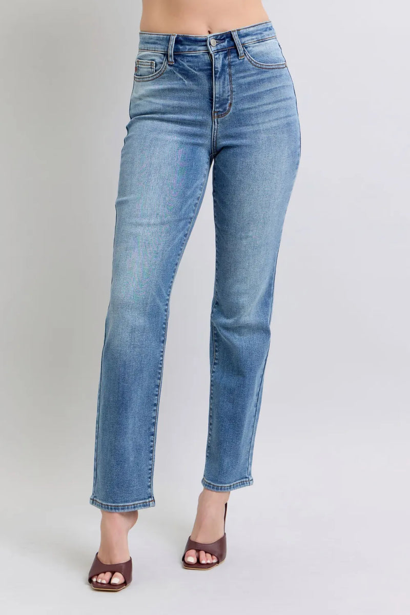 Blue jeans worn by a person on a plain background