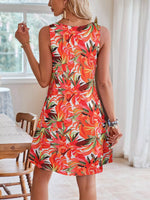 Woman wearing a colorful floral dress in a bright room.