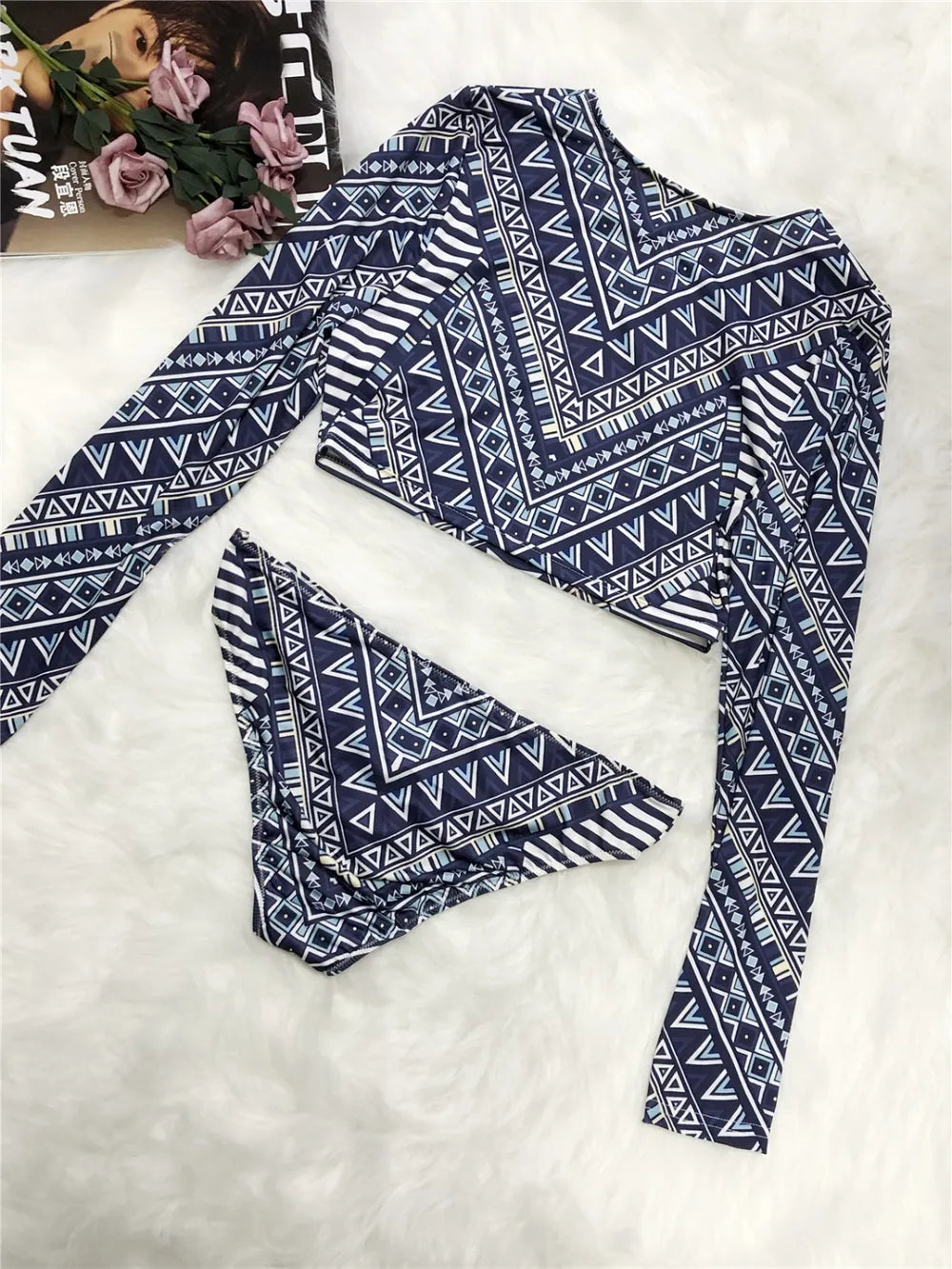 Blue and white patterned long-sleeve top on a white background