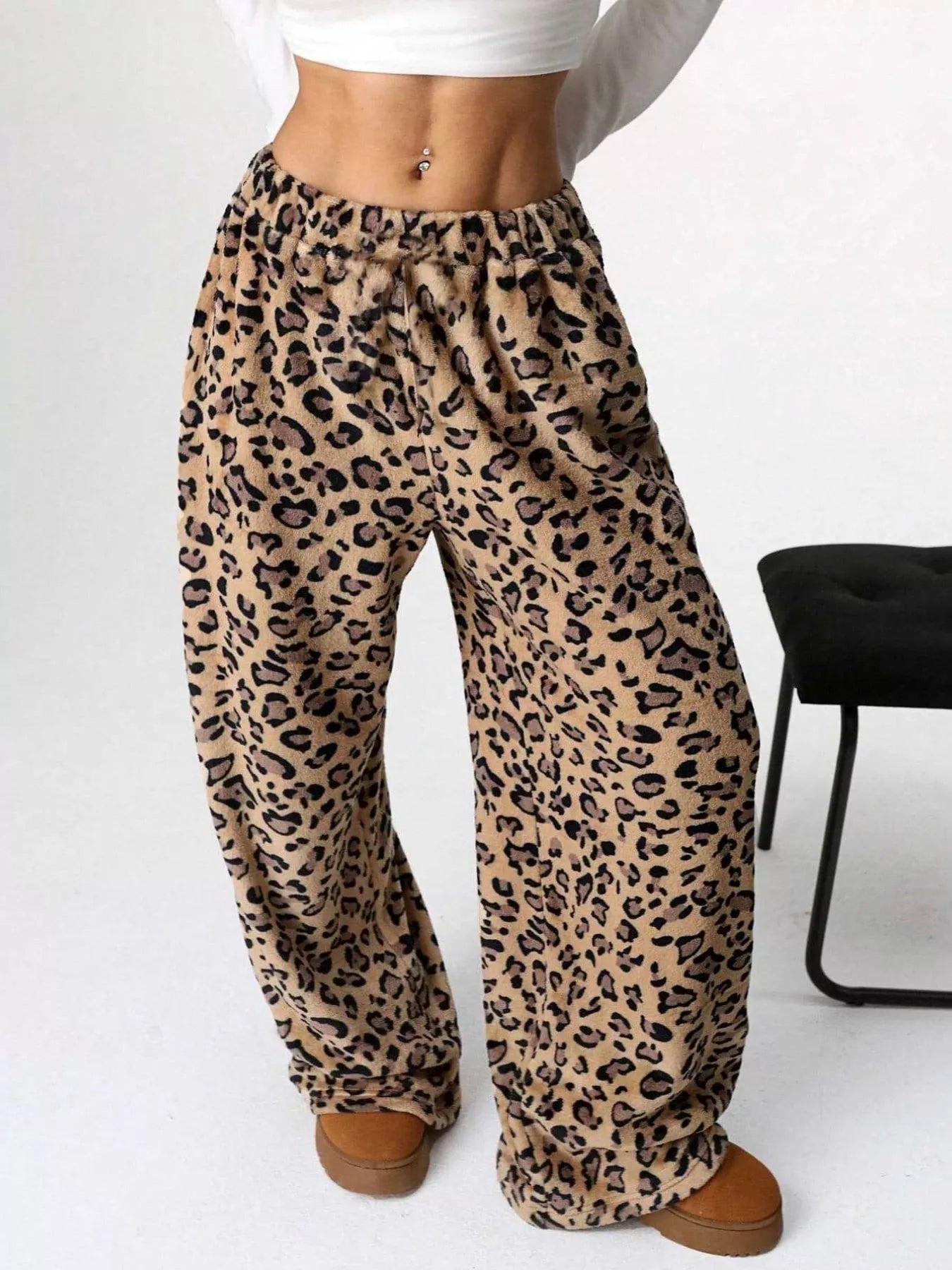 Leopard print pants worn by a person on a white background