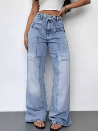 Person wearing light blue wide-leg jeans against a white background