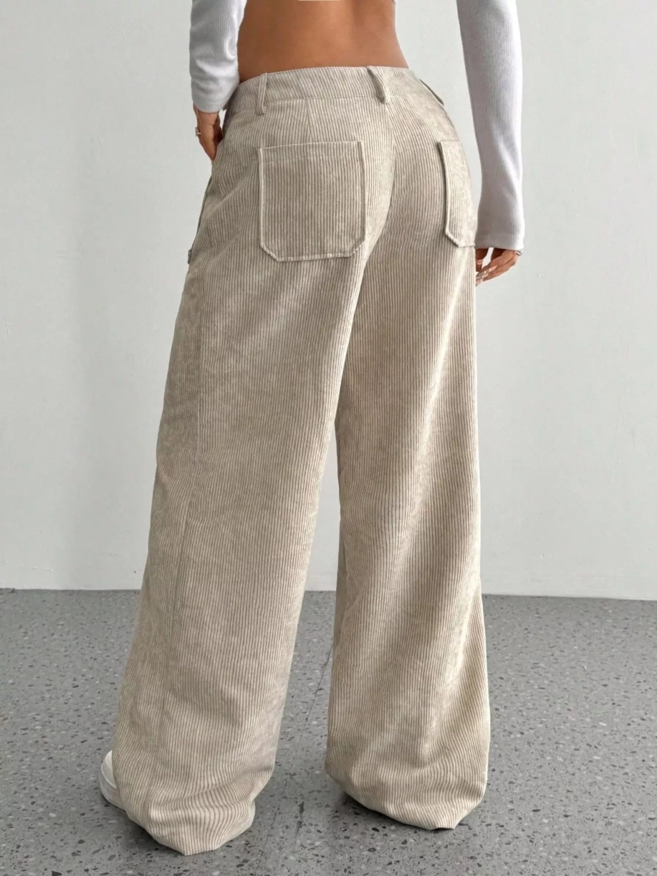 Beige corduroy pants worn by a person on a plain background