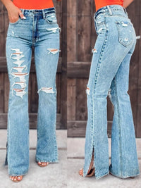 Distressed blue jeans with a high waist and flared legs worn by a person.