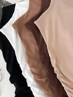 Close-up of black, brown, and beige long-sleeve shirts on a white background