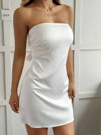 White strapless dress worn by a person against a white background