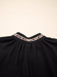 Black dress with lace trim on a beige background