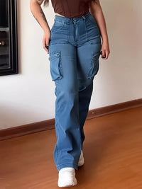 Person wearing blue cargo pants standing in a room with wooden floor and white wall.