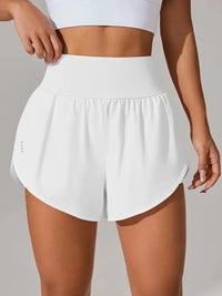 White athletic shorts worn by a person on a neutral background