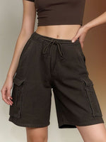 Person wearing dark brown cargo shorts with a neutral background