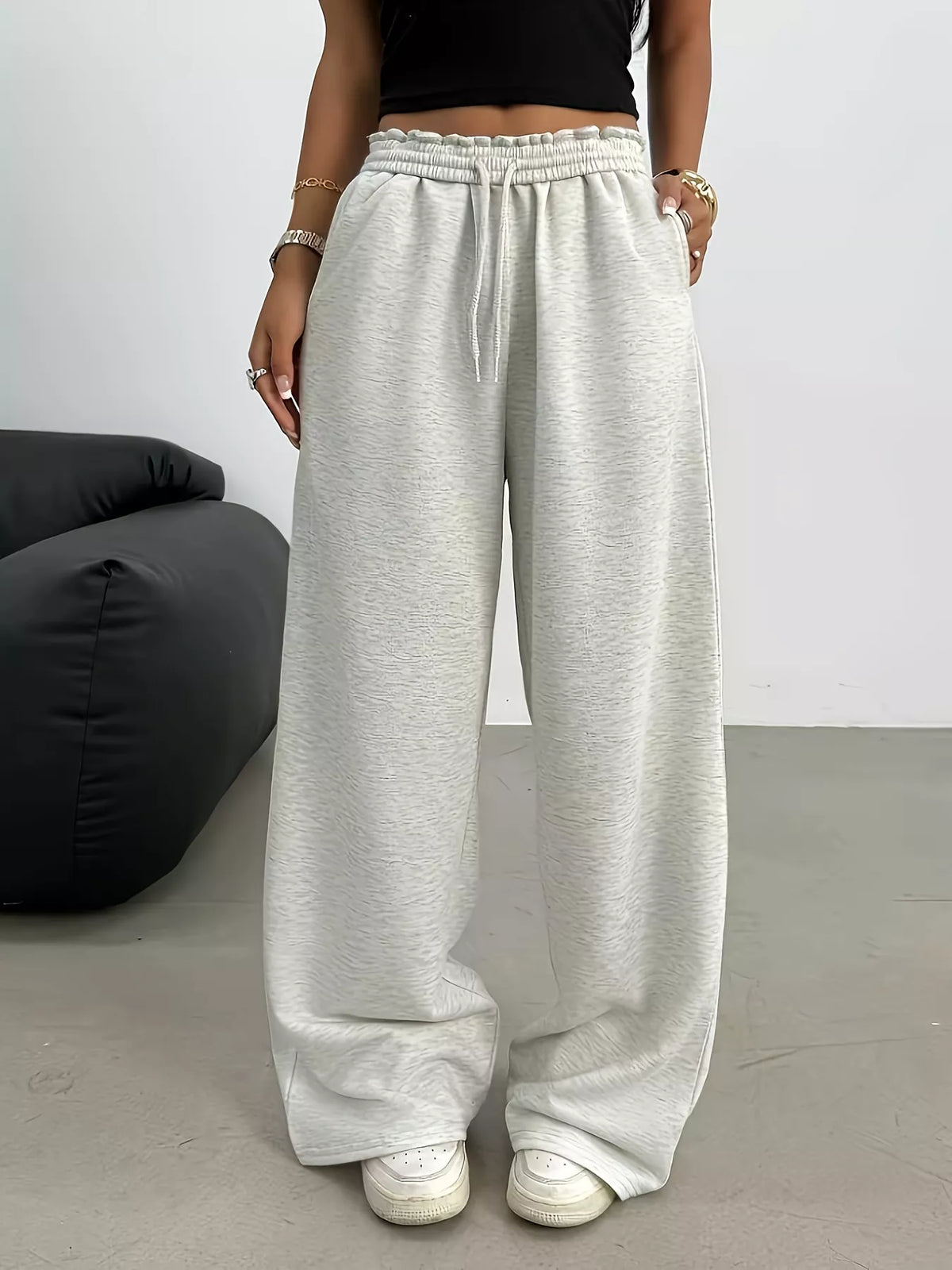 Person wearing light gray wide-leg pants with a blurred background