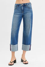 Blue jeans with rolled-up cuffs on a white background