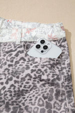 Leopard print shorts with a floral waistband on a beige background
