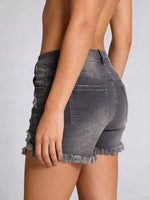 Gray denim shorts worn by a person on a plain background