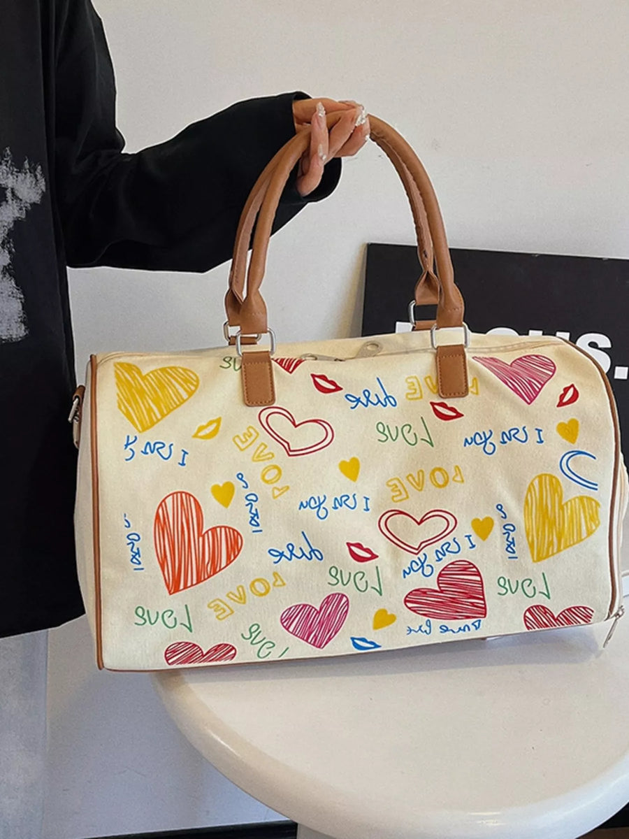 Handbag with colorful heart designs and text held by a person.