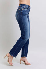 Blue jeans worn by a person on a plain background
