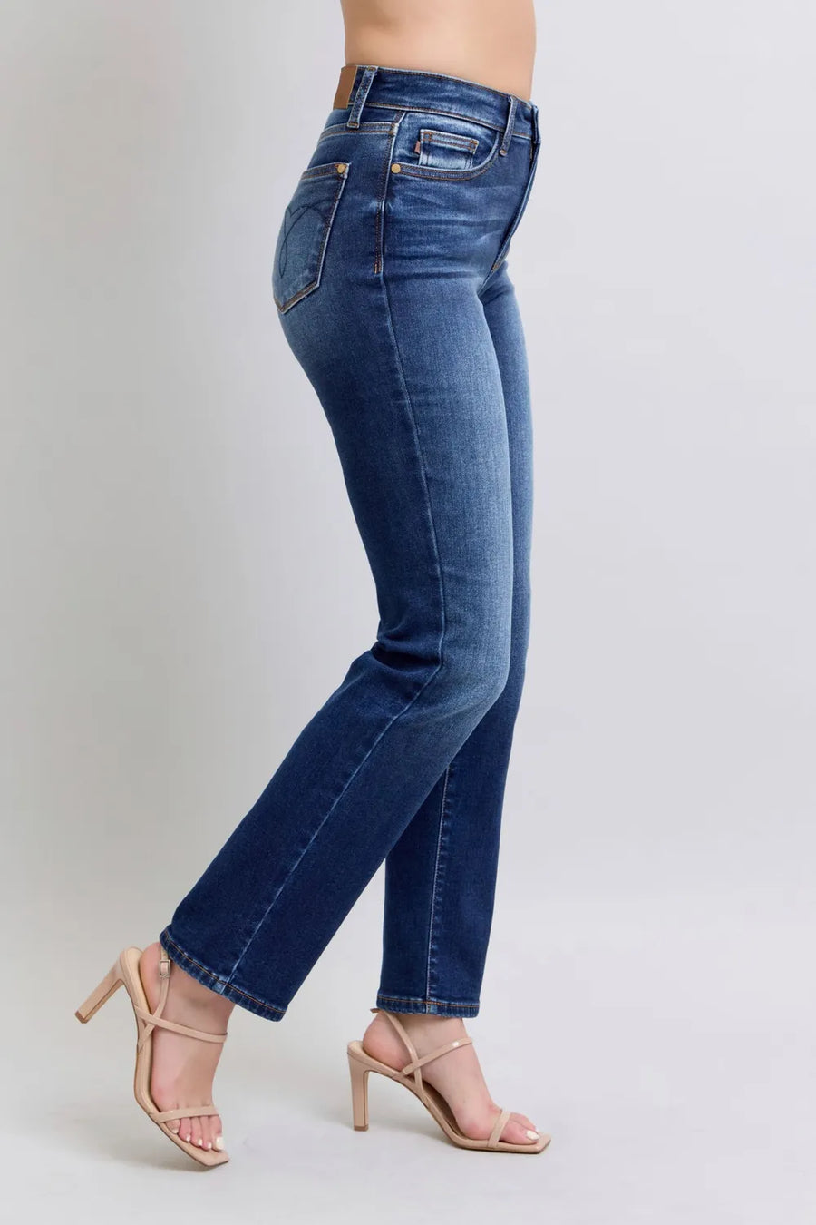 Blue jeans worn by a person on a plain background
