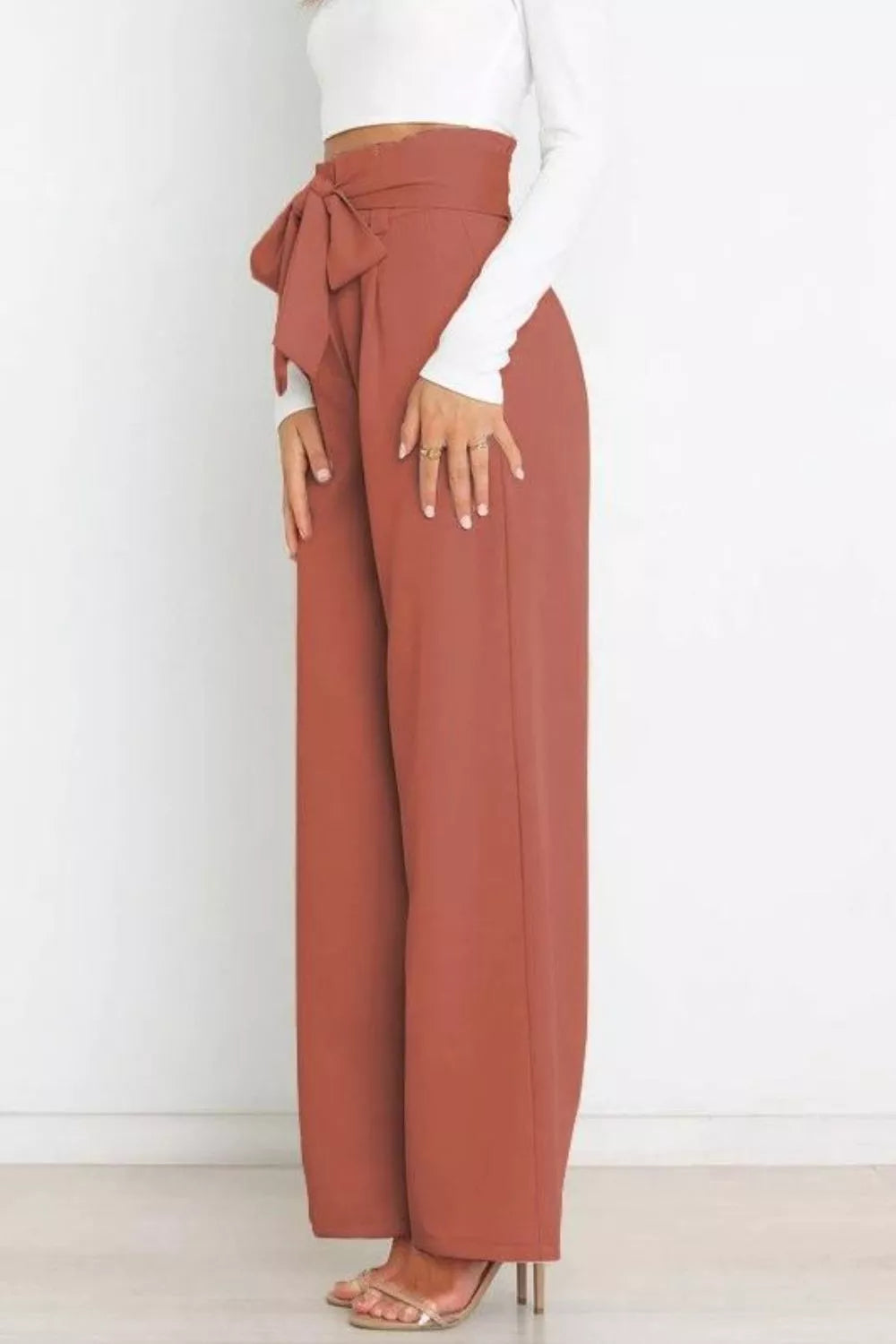 Brown wide-leg pants with a white top on a white background