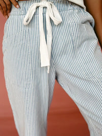 Striped pants with a drawstring waist on a plain background
