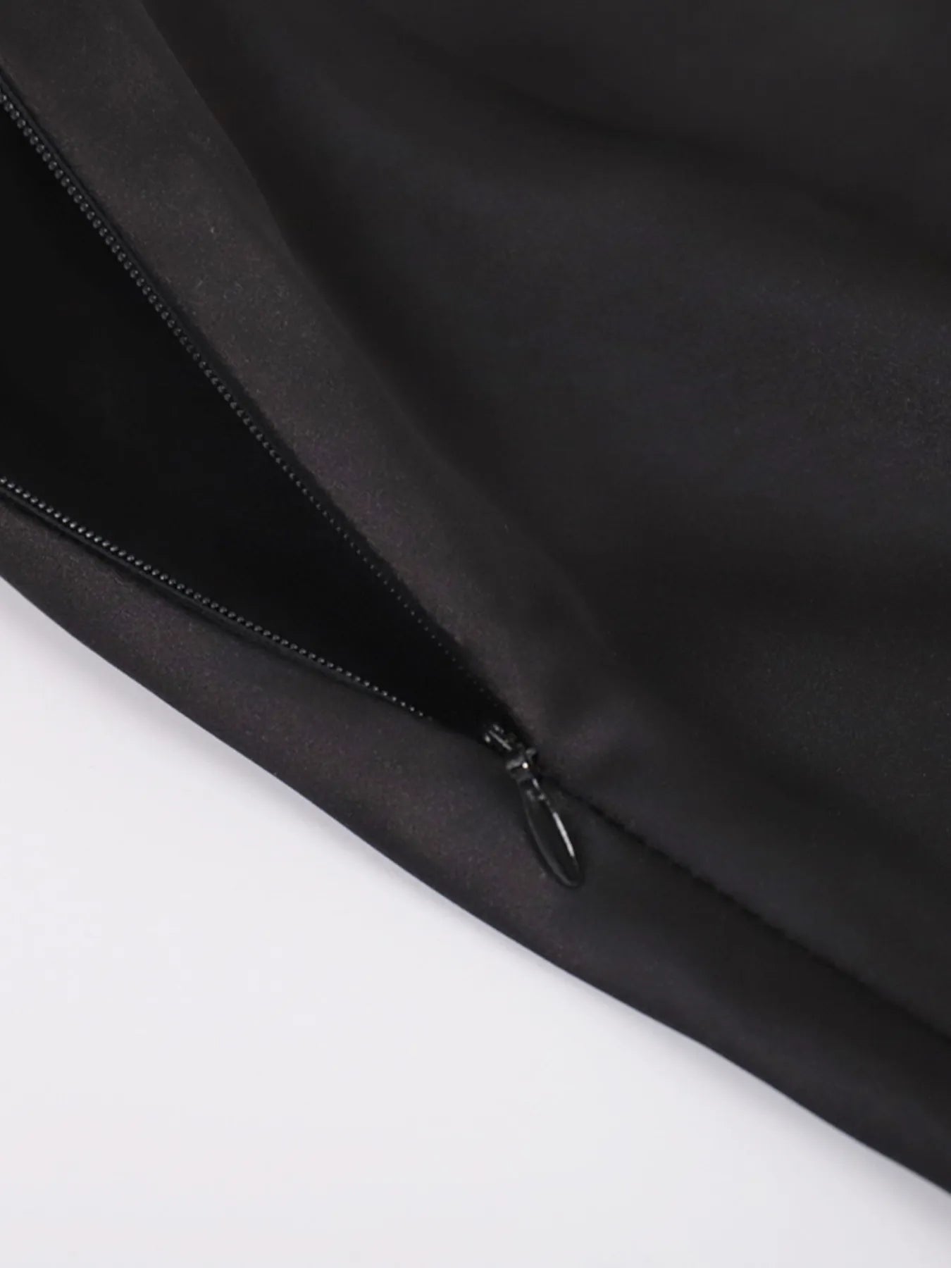 Close-up of a black jacket zipper on a white background