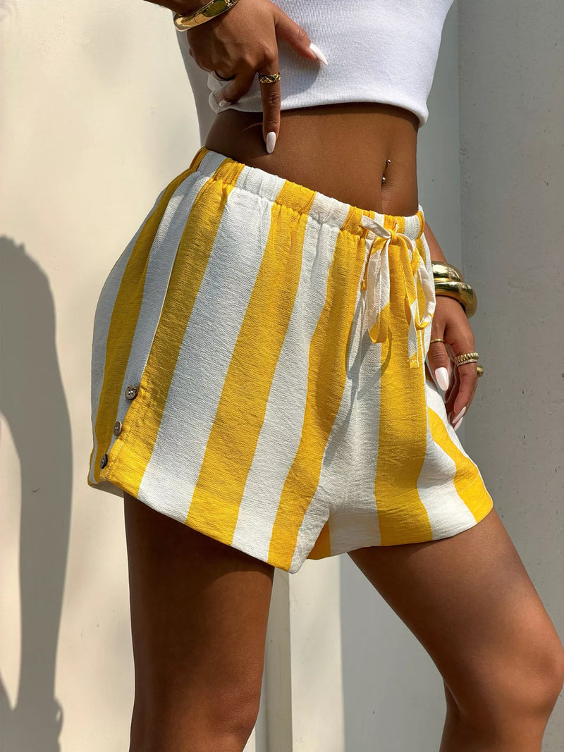 Person wearing yellow and white striped shorts with a neutral background