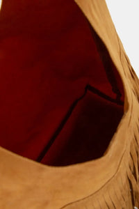 Close-up of a brown leather bag with fringe details.