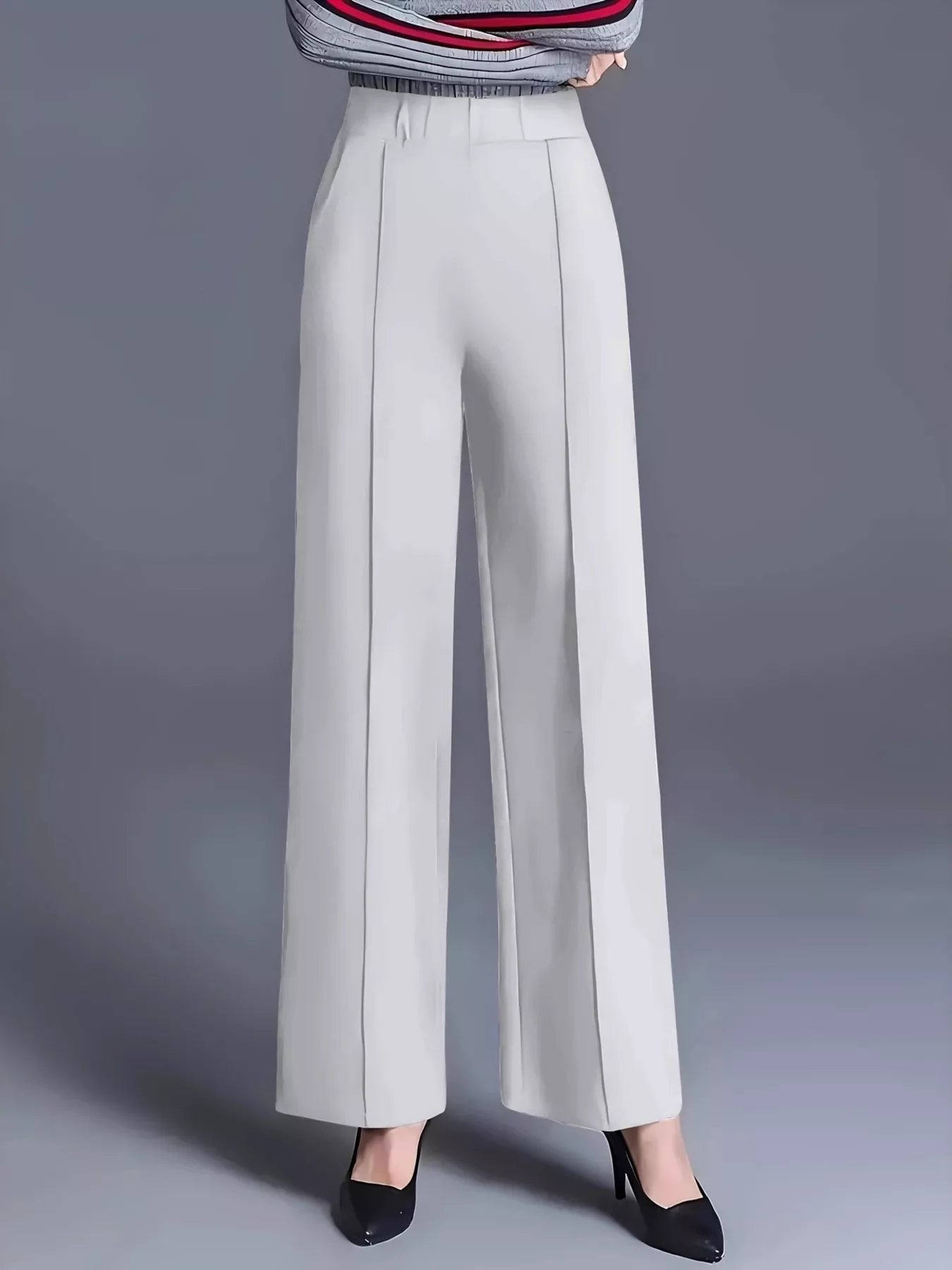 Light gray wide-leg pants worn with a striped top on a gray background