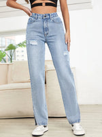 Person wearing light blue jeans with a blurred background