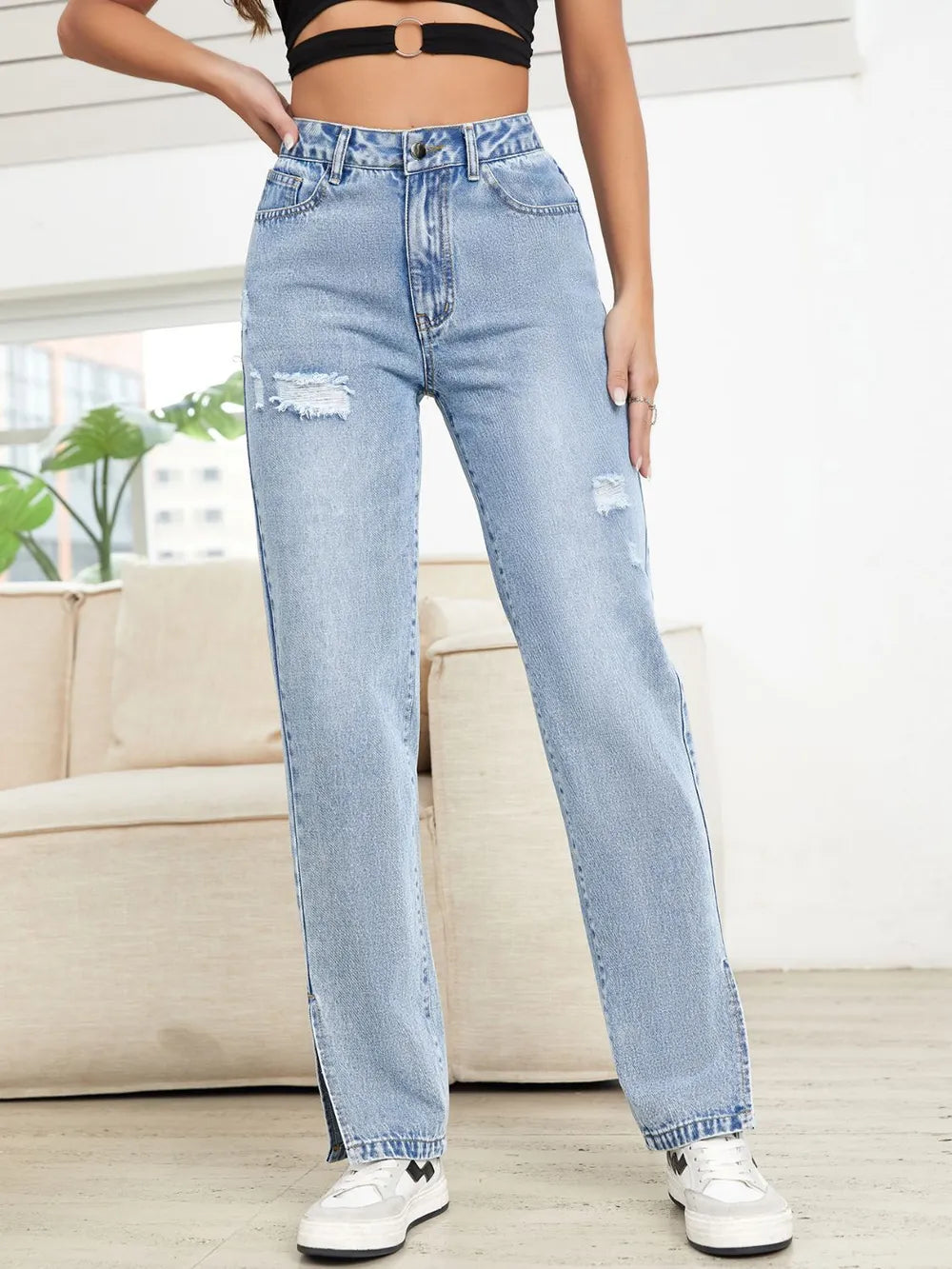 Person wearing light blue jeans with a blurred background