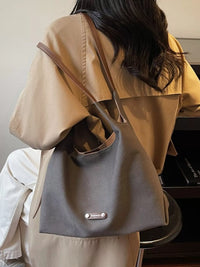 Person wearing a beige coat with a gray backpack, sitting in front of a piano.