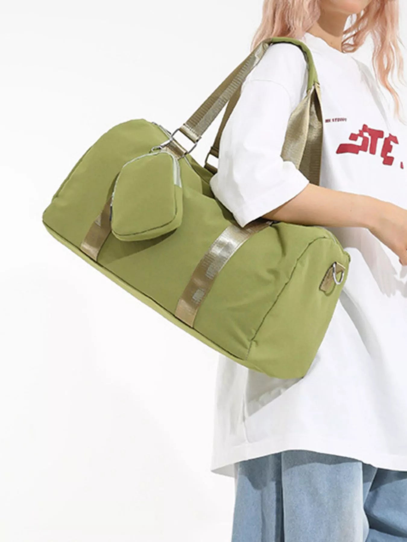 Person holding a green duffel bag with a plain background