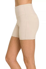 Beige shapewear shorts worn by a person on a white background