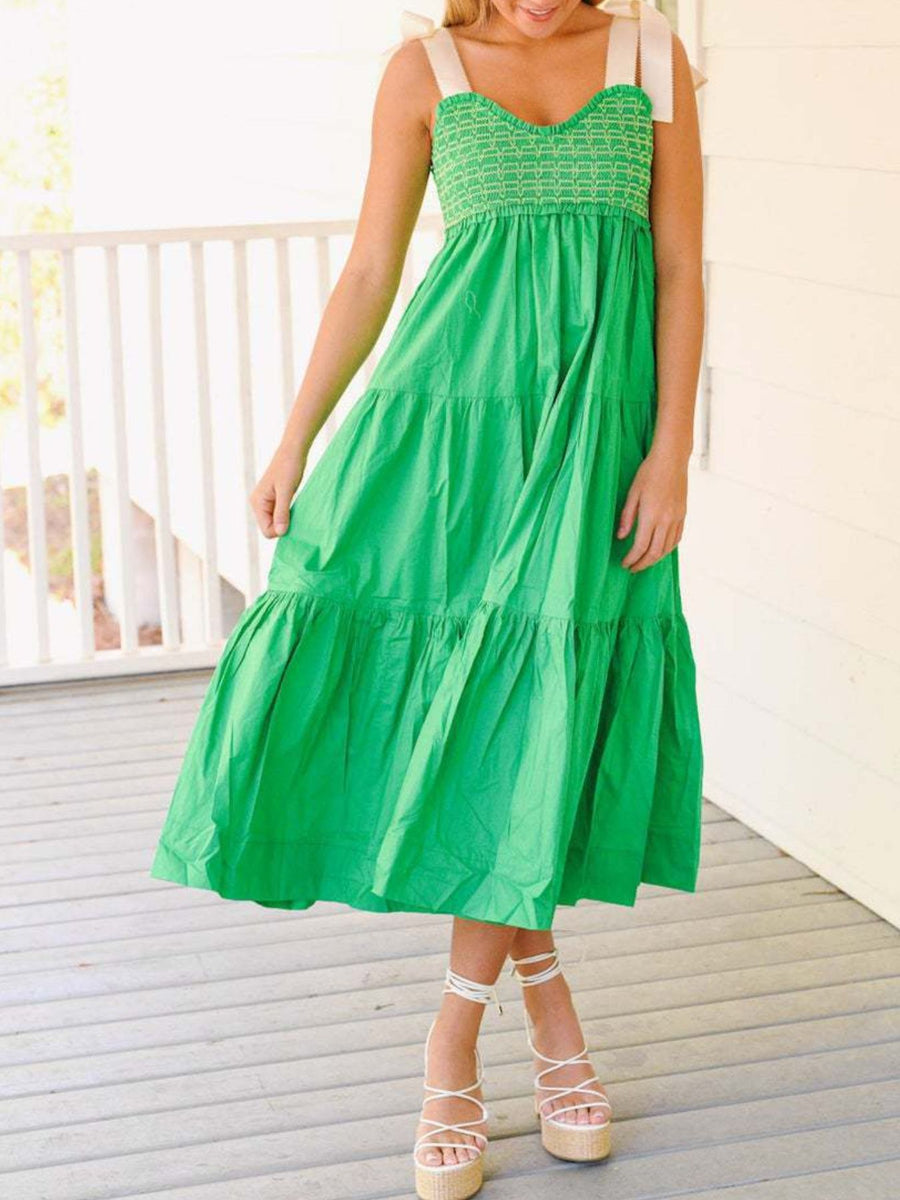 Woman wearing a green dress on a wooden deck